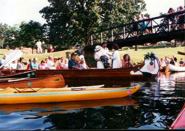 Family and friends in and around the big canoe near bridge on Lake 